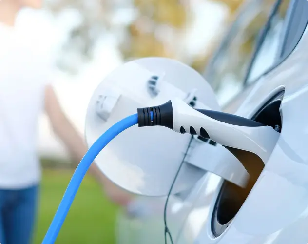 Close-up of an electric vehicle being charged, highlighting the connection point of the charger, symbolising green energy and sustainable power solutions.
